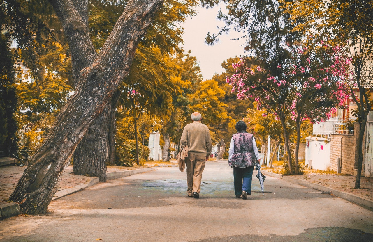 two elderly people walking
